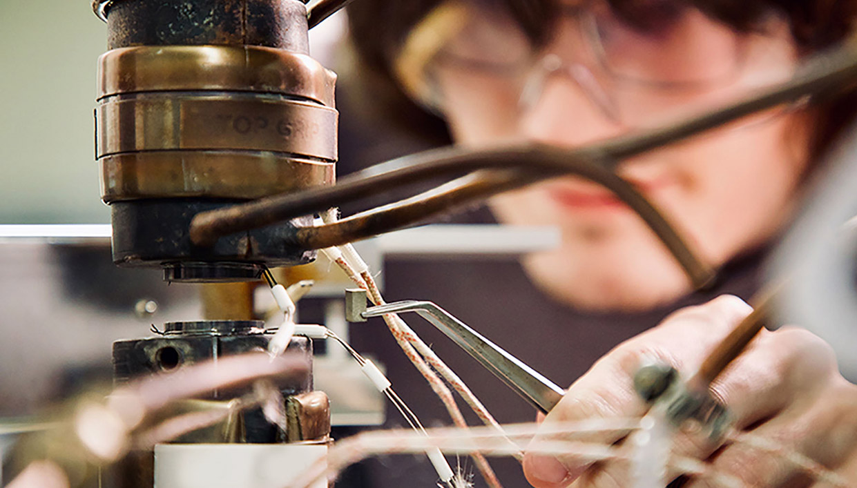 closeup of worker in safety gear setting up manufacturing equipment